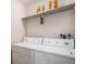Convenient laundry room features a washer and dryer, with shelving above for storage at 13241 E Asbury Dr # 203, Aurora, CO 80014