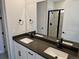 Well-lit bathroom featuring a double vanity, modern fixtures, and a glass-enclosed shower at 17125 W 92Nd Loop, Arvada, CO 80007