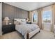 Inviting bedroom featuring a large bed, bedside tables, and light-filled windows with neutral curtains at 17125 W 92Nd Loop, Arvada, CO 80007