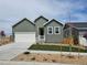 Charming single-Gathering home featuring a two-car garage, lovely front yard, and modern architectural details at 17125 W 92Nd Loop, Arvada, CO 80007