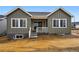Charming home featuring vertical siding, an inviting porch and a well-lit basement window at 17125 W 92Nd Loop, Arvada, CO 80007