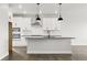 Modern kitchen with white cabinets, black countertops, stainless steel appliances, and hardwood flooring at 17125 W 92Nd Loop, Arvada, CO 80007