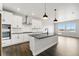 Modern kitchen features white cabinets, stainless steel appliances, a black island and dark hardwood floors at 17125 W 92Nd Loop, Arvada, CO 80007