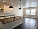 Open-concept kitchen with a central island, dark countertops, stainless steel appliances and hardwood floors at 17125 W 92Nd Loop, Arvada, CO 80007