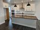 Bright, open kitchen with an island, pendant lights, white cabinets, and stainless steel appliances at 17125 W 92Nd Loop, Arvada, CO 80007