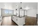 Bright modern kitchen features white cabinets, a center island, and views of the living room and dining room at 17125 W 92Nd Loop, Arvada, CO 80007