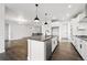 Modern kitchen features a center island with seating, stainless steel appliances, and views of the living area at 17125 W 92Nd Loop, Arvada, CO 80007