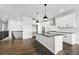 Well-lit kitchen featuring white cabinets, dark countertops, stainless steel appliances, and an island with pendant lights at 17125 W 92Nd Loop, Arvada, CO 80007