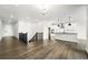 Open-concept living area featuring hardwood floors, stairs and a kitchen with an island and stainless steel appliances at 17125 W 92Nd Loop, Arvada, CO 80007