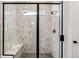 Modern glass shower with white and gray patterned tile, a window, and a built-in bench at 17125 W 92Nd Loop, Arvada, CO 80007