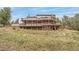 Expansive tiered deck overlooking hillside, supported by sturdy beams, and surrounded by rocks and grasses at 3961 Mossy Rock Ln, Evergreen, CO 80439