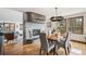 Elegant dining room featuring a modern light fixture, a stylish fireplace, and views of the scenic surroundings at 3961 Mossy Rock Ln, Evergreen, CO 80439
