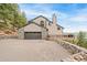 Beautiful home exterior featuring stone accents, a built-in deck, and a private driveway at 3961 Mossy Rock Ln, Evergreen, CO 80439