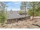 Charming home with stone accents, a lush landscape, and picturesque natural surroundings at 3961 Mossy Rock Ln, Evergreen, CO 80439