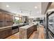 Modern kitchen featuring an oversized island with marble countertops, custom cabinetry, and stainless steel appliances at 3961 Mossy Rock Ln, Evergreen, CO 80439