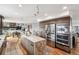 Open concept kitchen featuring an island with marble countertops, a built-in refrigerator, and a view into the dining room at 3961 Mossy Rock Ln, Evergreen, CO 80439