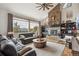 Bright living room with a stone fireplace, plush seating, and large windows offering breathtaking mountain views at 3961 Mossy Rock Ln, Evergreen, CO 80439