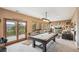 Open living space with pool table and multiple window and door access to the view at 3961 Mossy Rock Ln, Evergreen, CO 80439