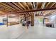 Large unfinished basement features exposed rafters, concrete floor and storage shelves at 9921 W Edenburg Pl, Littleton, CO 80127