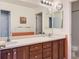 Bathroom featuring double sinks with mirror and lighting, and a view of the toilet and shower at 9921 W Edenburg Pl, Littleton, CO 80127