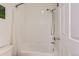 Bathroom with white tiled walls, a shower and bathtub combination, and a curved shower curtain rod at 9921 W Edenburg Pl, Littleton, CO 80127
