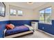 Bedroom with blue accent stripe, and multiple windows offering plenty of natural light at 9921 W Edenburg Pl, Littleton, CO 80127