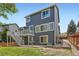 Rear exterior of a multi-story home with a deck, patio, landscaped yard, and walkway at 9921 W Edenburg Pl, Littleton, CO 80127