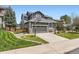 Charming home with a basketball hoop, stone accents, a well-manicured lawn, and a two-car garage at 9921 W Edenburg Pl, Littleton, CO 80127