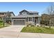Inviting home with stone accents, a well-manicured lawn, and a two-car garage at 9921 W Edenburg Pl, Littleton, CO 80127