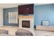 Close-up of the modern fireplace with a wooden mantel and tiled surround in the living room at 9921 W Edenburg Pl, Littleton, CO 80127
