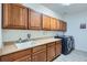 Functional laundry room with ample cabinet space and modern appliances at 9921 W Edenburg Pl, Littleton, CO 80127