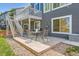 Back patio featuring a dining set with a grass and stone yard at 9921 W Edenburg Pl, Littleton, CO 80127