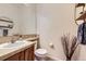 Bright powder room with round mirror, vanity, and stylish decor at 9921 W Edenburg Pl, Littleton, CO 80127