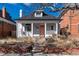 Charming home with a cozy front porch, white columns, and a vibrant peach-colored door at 613 S Logan St, Denver, CO 80209