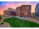Backyard with a well-maintained lawn, patio, gravel area, and white picket fence at sunset at 5311 Blue Lunar Ln, Castle Rock, CO 80104