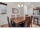 Dining room with wooden table, chairs and stylish chandelier with adjacent kitchen area at 5311 Blue Lunar Ln, Castle Rock, CO 80104