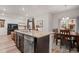 Kitchen island with stone counters connects living room and dining area, with natural light at 5311 Blue Lunar Ln, Castle Rock, CO 80104