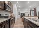 Modern kitchen featuring stainless steel appliances, granite countertops, and adjacent living area at 5311 Blue Lunar Ln, Castle Rock, CO 80104