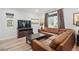 Relaxing living room featuring a large leather sofa, a coffee table, and a television at 5311 Blue Lunar Ln, Castle Rock, CO 80104