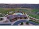 Aerial view of a community pool and clubhouse with lush green surroundings and ample parking at 5311 Blue Lunar Ln, Castle Rock, CO 80104