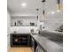 Contemporary bar area with sleek black countertop, pendant lighting, modern sink, and ample storage shelves at 1518 S Columbine St, Denver, CO 80210
