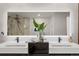 Elegant bathroom with double sinks, sleek black cabinetry, and a large, illuminated mirror at 1518 S Columbine St, Denver, CO 80210