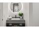 Modern bathroom with a large circular mirror, sleek faucet, and stylish vanity with stone countertop at 1518 S Columbine St, Denver, CO 80210