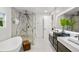 Modern bathroom featuring a glass-enclosed shower, soaking tub, and double vanity at 1518 S Columbine St, Denver, CO 80210