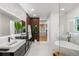 Contemporary bathroom with double vanity, wood accent wall, soaking tub, and glass shower at 1518 S Columbine St, Denver, CO 80210
