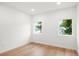Bright, empty bedroom with hardwood floors, two windows, and neutral paint, ready for personalization at 1518 S Columbine St, Denver, CO 80210