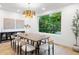 Bright dining room with a large window and nature views, with modern table and gold light fixture at 1518 S Columbine St, Denver, CO 80210