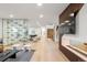 Bright, open-concept living room with modern decor, hardwood floors, and large glass wine storage at 1518 S Columbine St, Denver, CO 80210