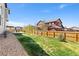 Large backyard featuring mature trees, a small garden, and full wood fencing at 6739 Blue Spruce St, Frederick, CO 80530