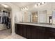 Bathroom with double sinks, granite counters, tile flooring, and walk-in closet at 6739 Blue Spruce St, Frederick, CO 80530